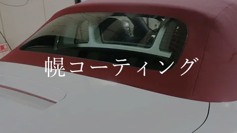 White convertible with a red soft top and Japanese text overlaid on the rear window reading 'コーティング'