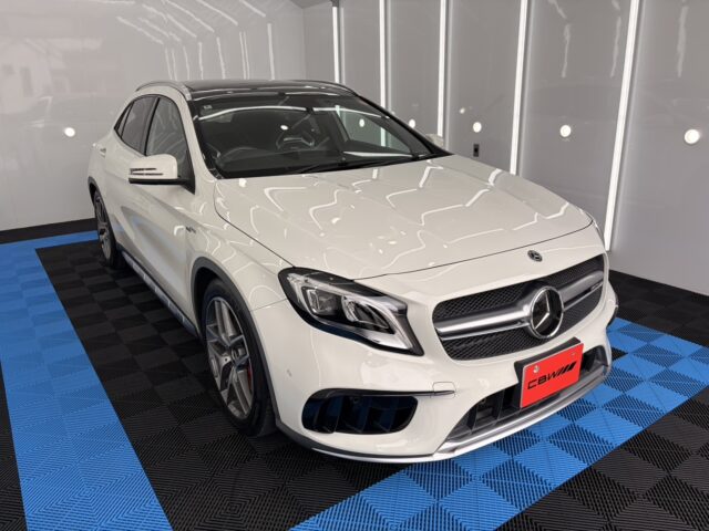 White Mercedes-Benz SUV in a bright showroom with a blue and black checkered floor=